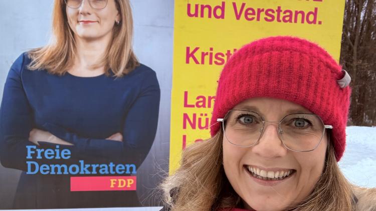 Landratskandidatin vor Großflächenplakat